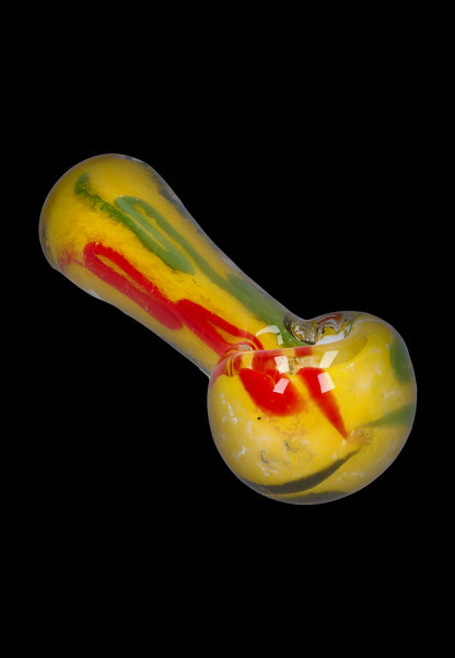 Angled close-up of the Smoke Cartel Color Frit Spoon Pipe - 3 in. showing yellow glass with red and green frit lines against a black background