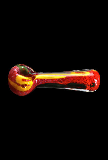 Side view of the Smoke Cartel Color Frit Spoon Pipe - 3 in., a small yellow-and-red glass handpipe with mottled frit texture against a black background