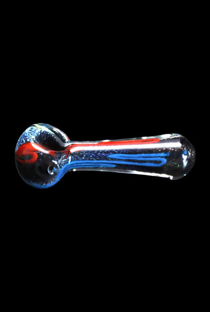 Side view of the Smoke Cartel Color Frit Spoon Pipe - 3 in., a clear glass spoon pipe with internal red and blue frit lines against a black background.