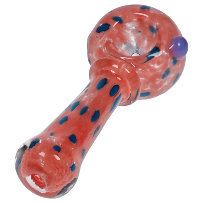 Angled close-up of the Smoke Cartel Frit with Twisted Mouthpiece Spoon Pipe - 4 in., showing a coral glass body with scattered blue frit dots and a rounded bowl.