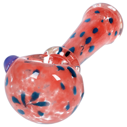 Angled close-up of the Smoke Cartel Frit with Twisted Mouthpiece Spoon Pipe - 4 in., showing a pink glass body with scattered blue frit dots and reflective highlights.