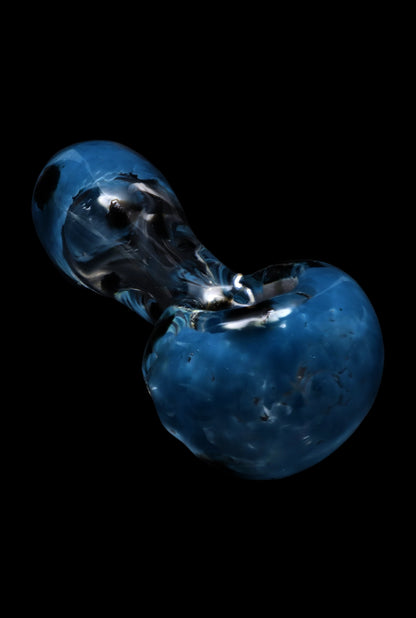 Angled close-up of the Smoke Cartel Colour Frit with Dots Spoon Pipe - 2.5 in. showing its glossy blue swirled bowl and reflective neck against a black background