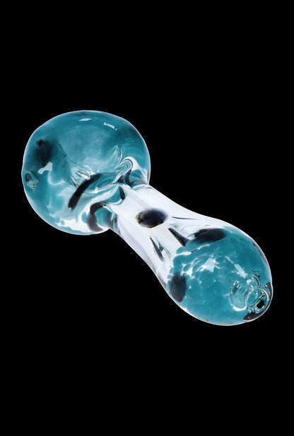 Angled close-up of the Smoke Cartel Colour Frit with Dots Spoon Pipe - 2.5 in., showing a blue-green glass bowl and mouthpiece with black dot accents on a black background