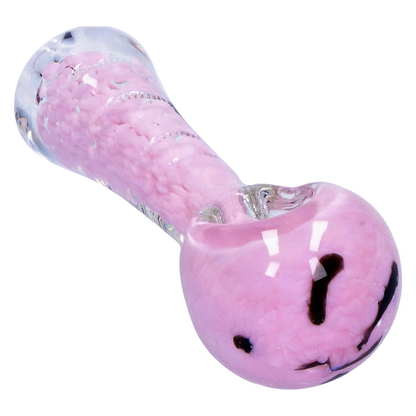 Angled close-up of the Smoke Cartel Frit Marble Rim Pastel Spoon Pipe - 3.5 in., showing its glossy pink frit body, clear glass rim, and dark swirl accents.
