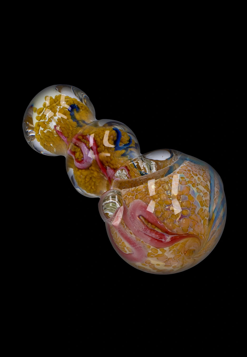 Angled close-up of the Smoke Cartel Fancy Frit Spoon Pipe - 3.5 in. showing yellow frit patterns, pink and blue swirls, and glossy reflections on black.