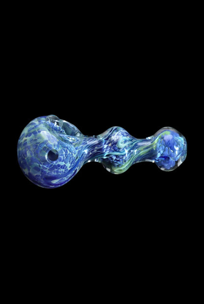 Top-down close-up of the Smoke Cartel Fancy Frit Spoon Pipe - 3.5 in. showing a milky green and blue swirled glass body against a black background.