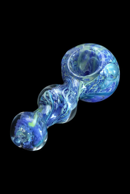 Angled close-up of the Smoke Cartel Fancy Frit Spoon Pipe - 3.5 in. showing swirling milky green and blue frit patterns against a black background