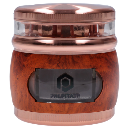 Close-up front view of the Smoke Cartel Glossy 3-Stage Grinder - 62mm showing its metallic red top, clear middle chamber, and wood-textured lower body with a small window.