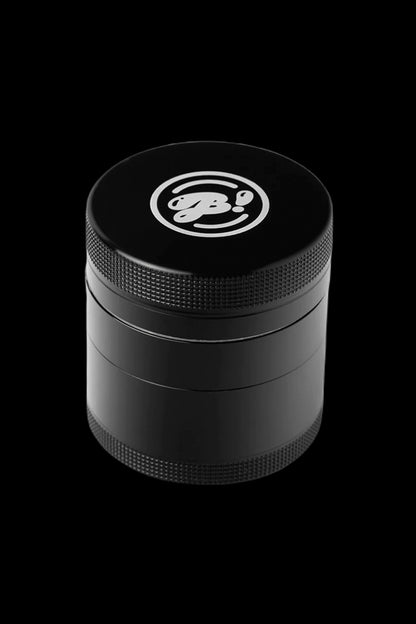 Black four-chamber cannabis grinder with a white logo on the lid.