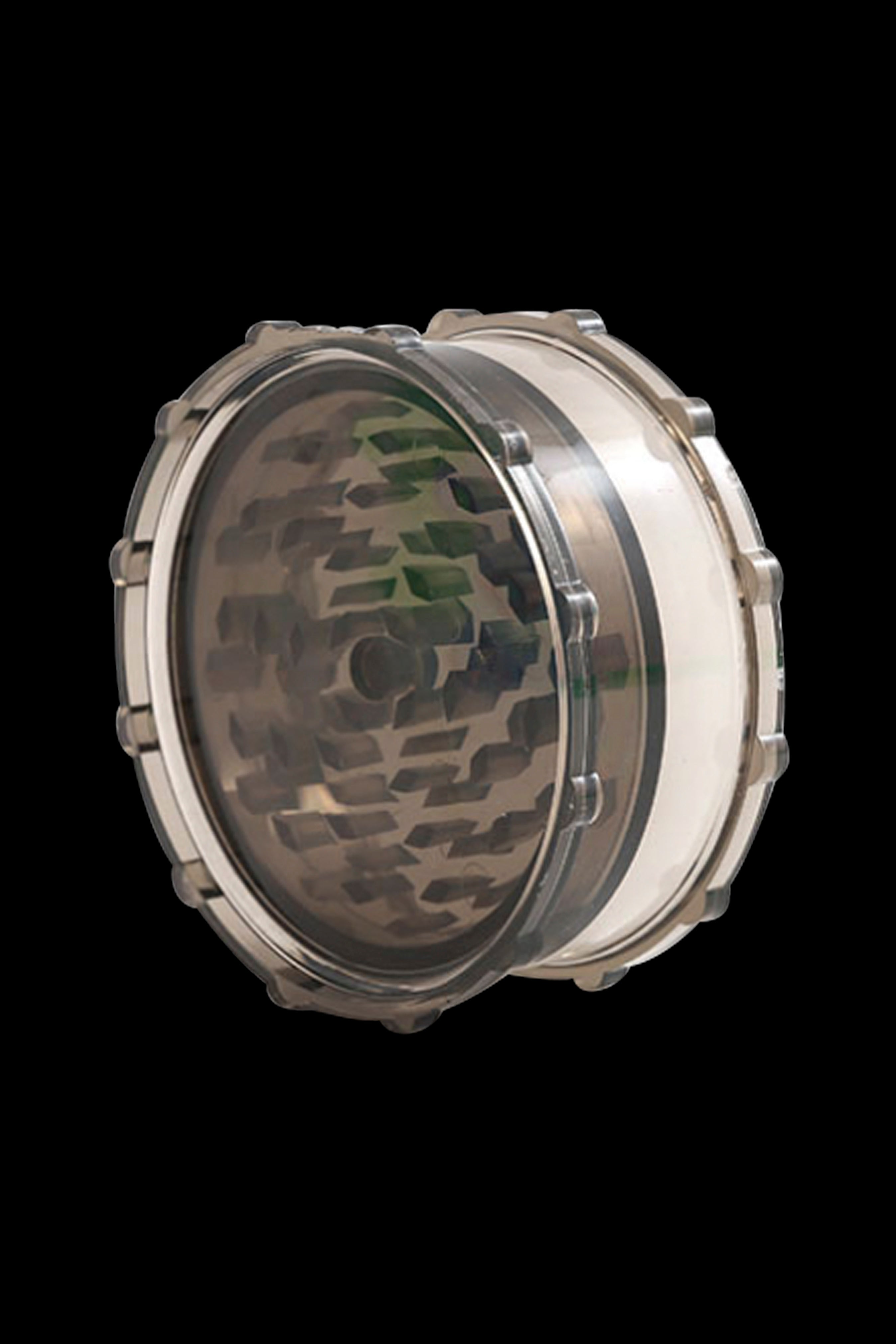 Clear cannabis grinder with metallic grinding teeth.