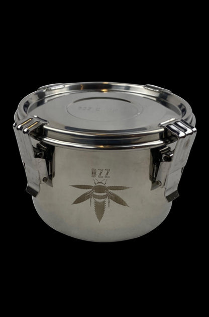 Silver cannabis storage container with a leaf emblem.