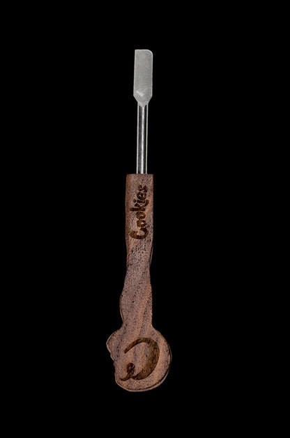 Brown and silver cannabis dab tool with "Cookies" branding against a black background.