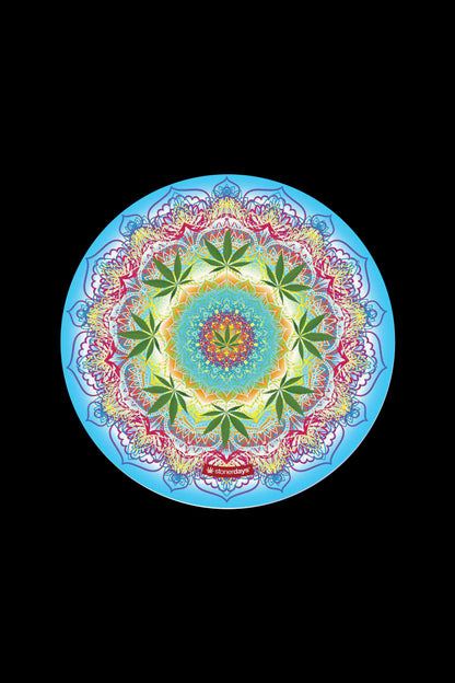 Top-down view of a colorful mandala with green leaf motifs on a blue field, featuring the StonerDays Mandala Dab Mat Combo - 4 Pack.