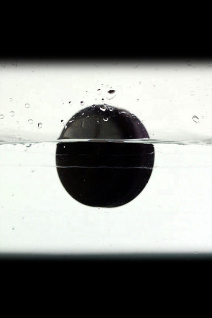 Black cannabis bubble partially submerged in water, creating a striking visual.