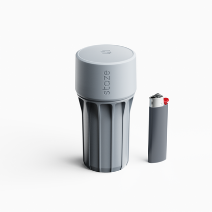 Close-up, slightly elevated view of the matte grey STAZE PRESERVE cylinder showing its ridged body and embossed top against a white background.