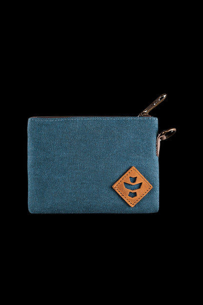 Close-up of the teal fabric Revelry Supply Smell Proof Zippered Small Stash Bag - The Mini Broker showing the top zipper pull and tan stitched leather logo.