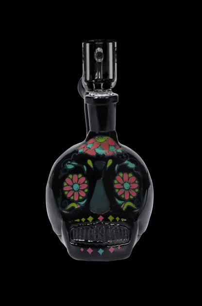 Black glass water pipe shaped like a sugar skull with colorful floral detailing.