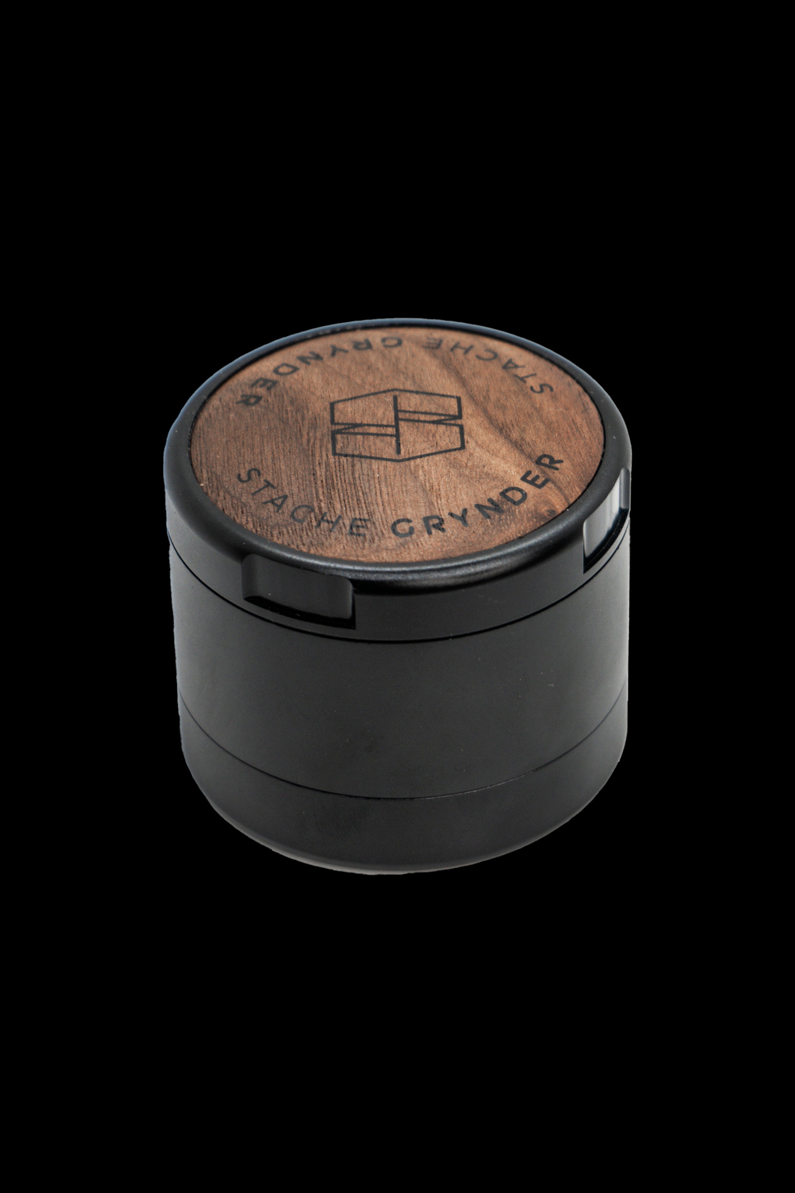 Black four-piece grinder with a wood-grain top engraved with “Stache Grynder.”