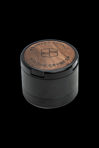 Black four-piece grinder with a wood-grain top engraved with “Stache Grynder.”