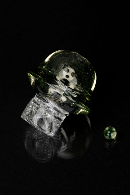 Abstract studio shot of a glass cannabis water pipe against a black background.