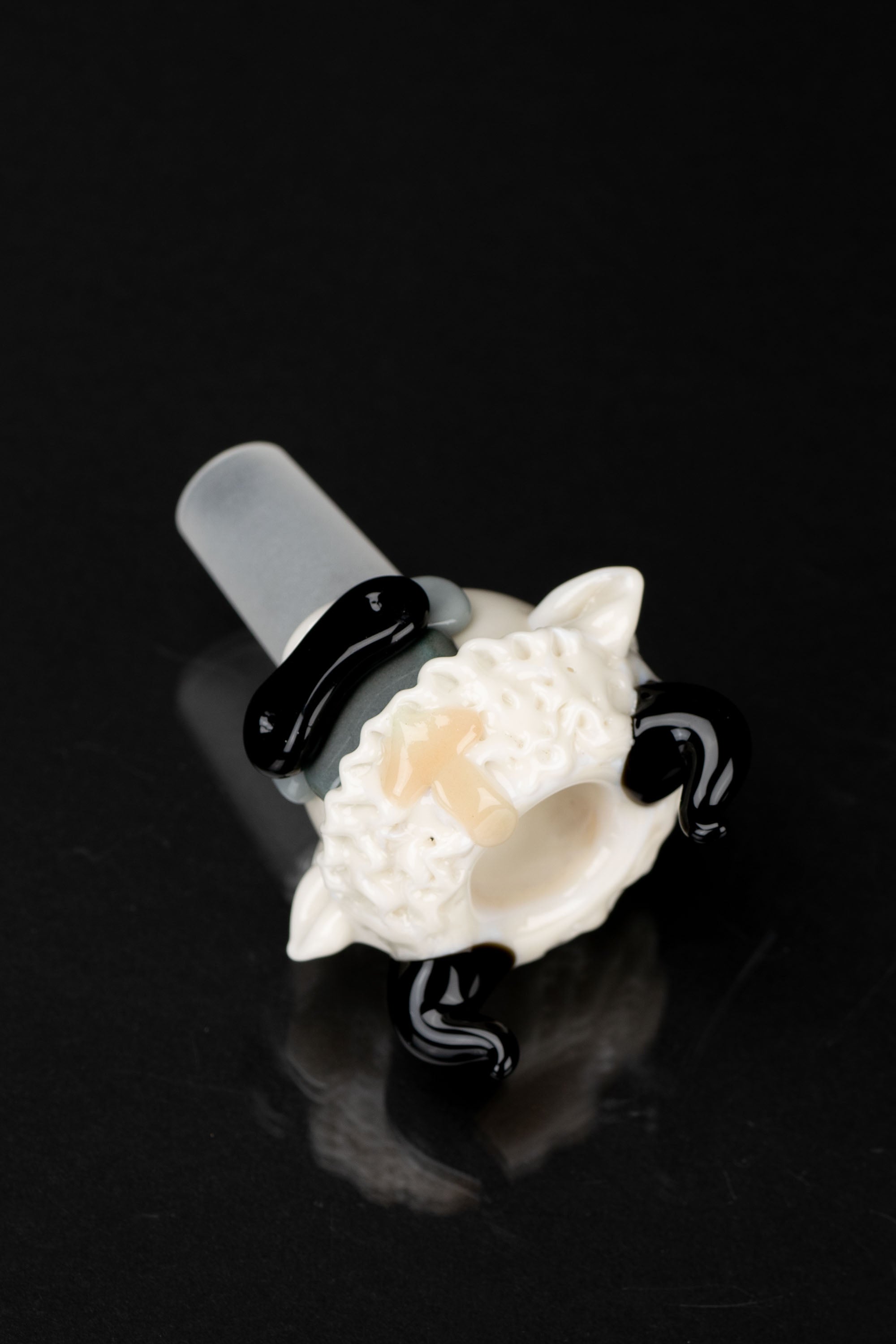 Glass cannabis bowl with a sculpted flower design, black accent ring, and reflective surface against a black background.