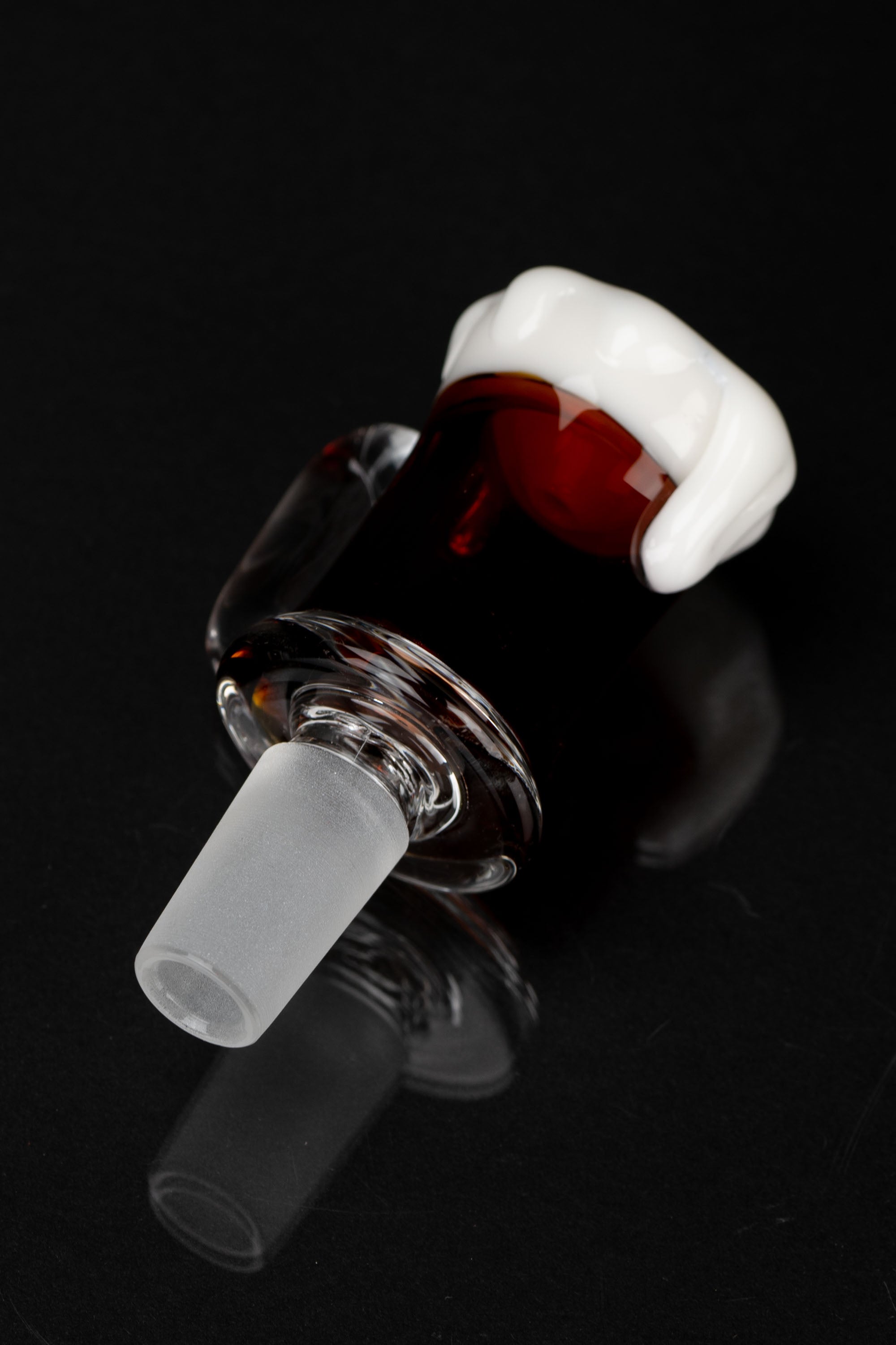 Red glass cannabis bowl with white accent, isolated on black.