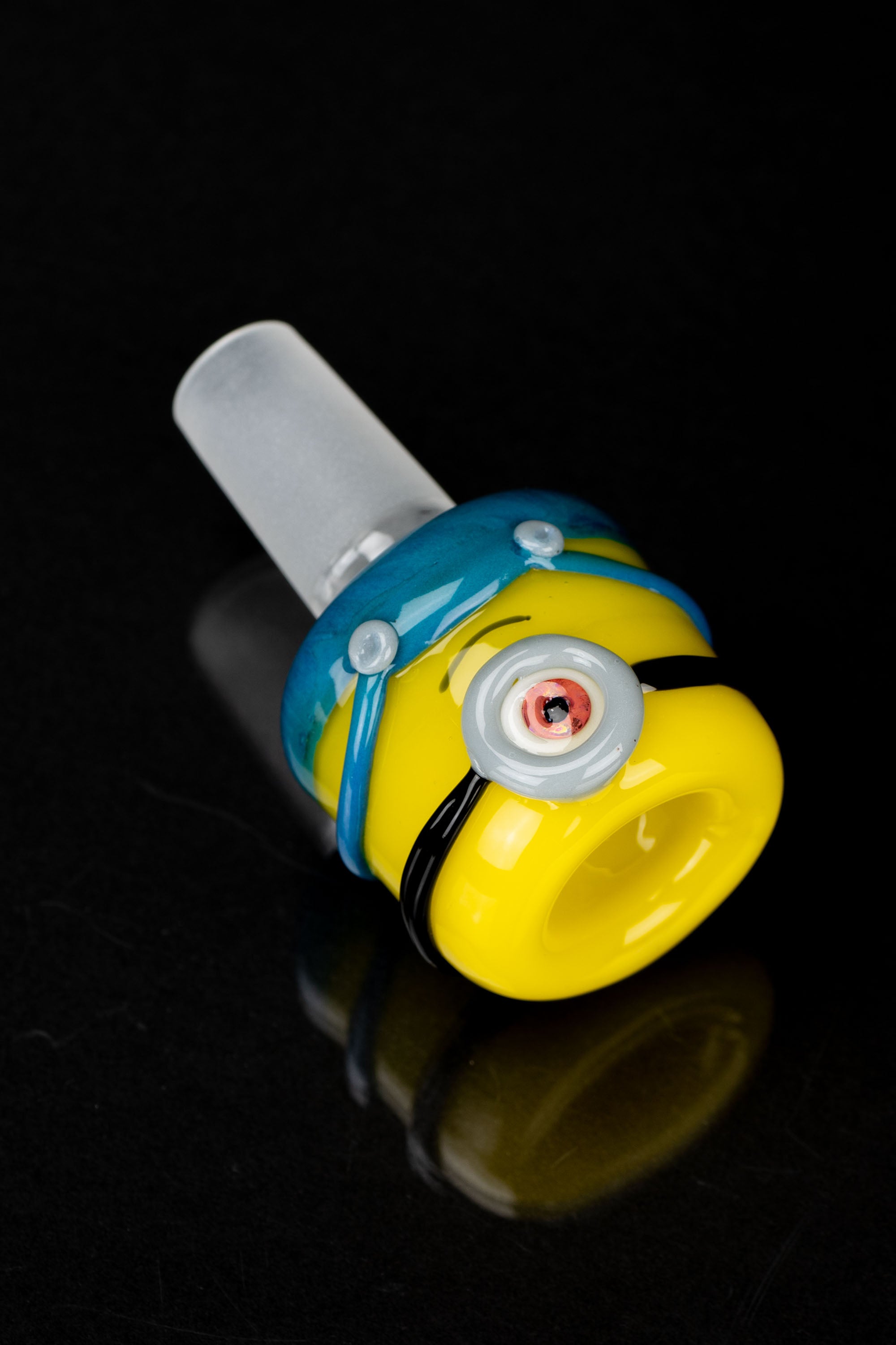 Hand-blown glass cannabis pipe shaped like a Minion character, featuring yellow and blue bands with oversized goggles.