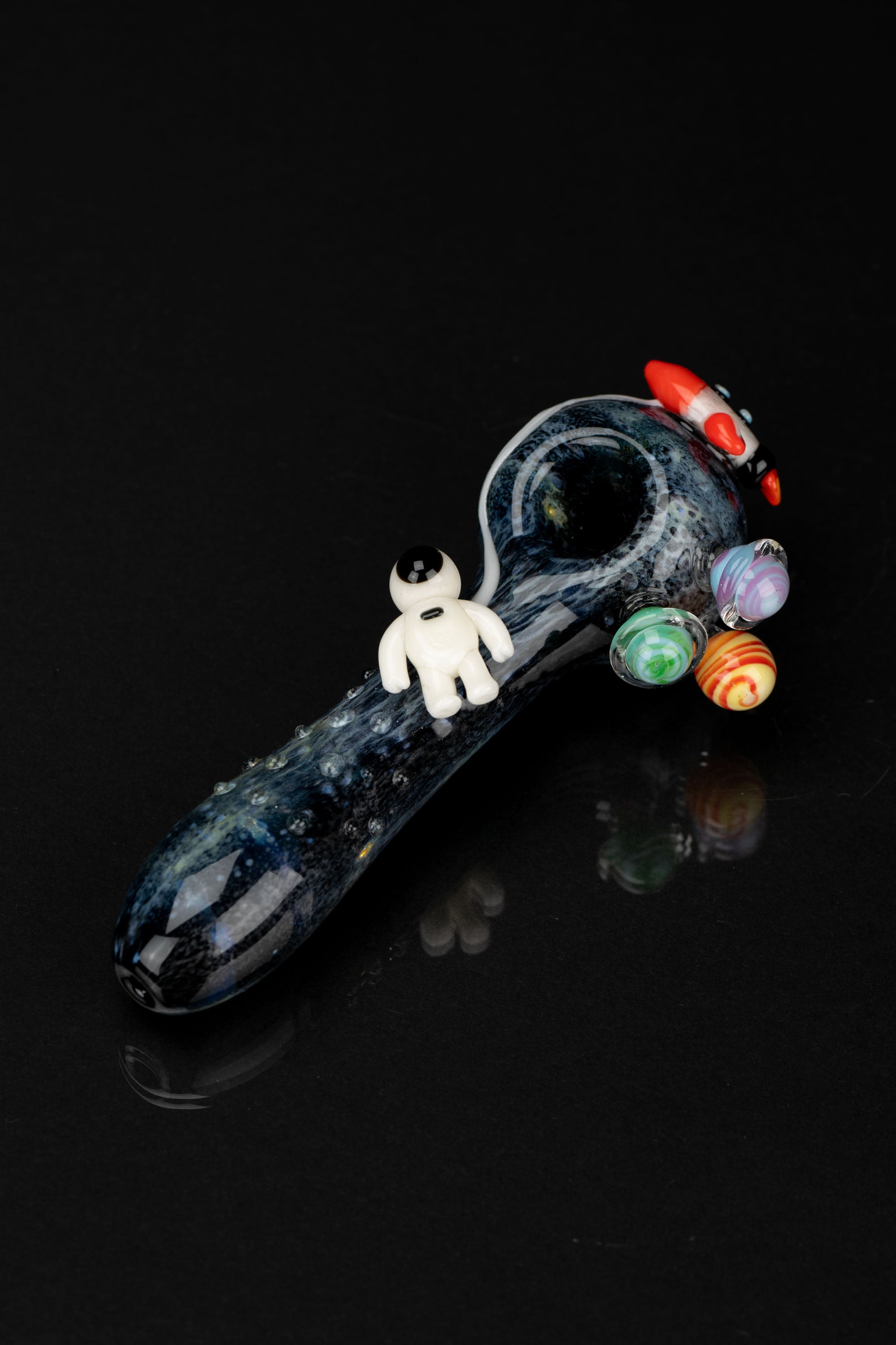 Hand-blown glass pipe with a space theme, featuring planetary orbs and a miniature astronaut figure.