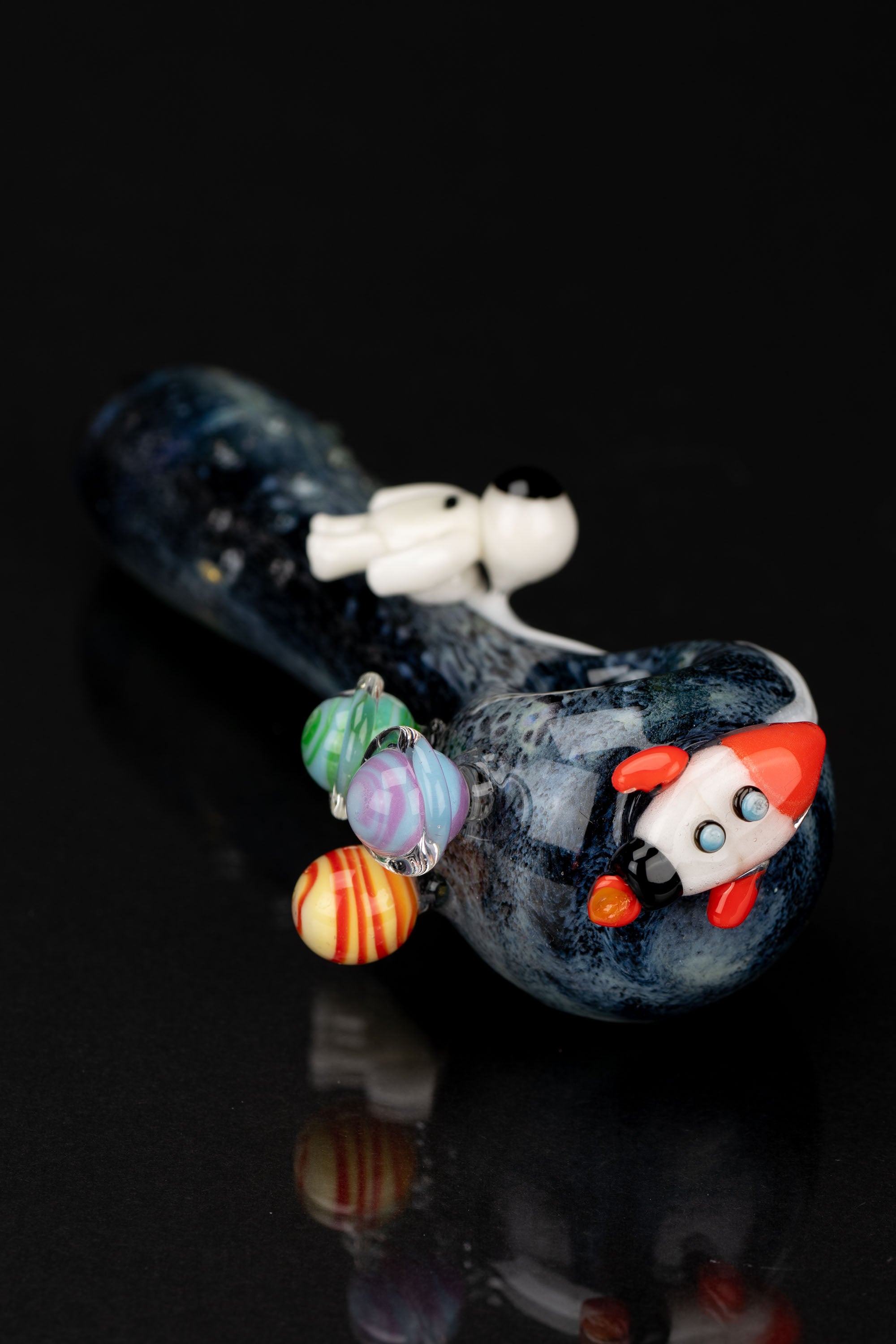 Hand-blown glass pipe with a space theme, featuring planets and a rocket ship design.