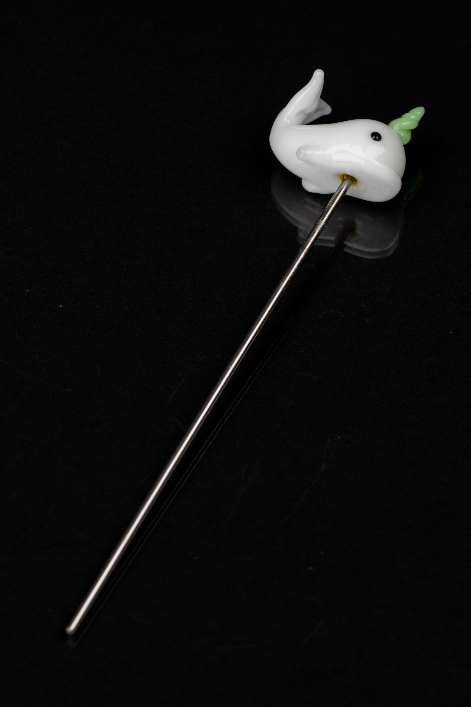 Glass ghost dab tool with green accent on a black background.