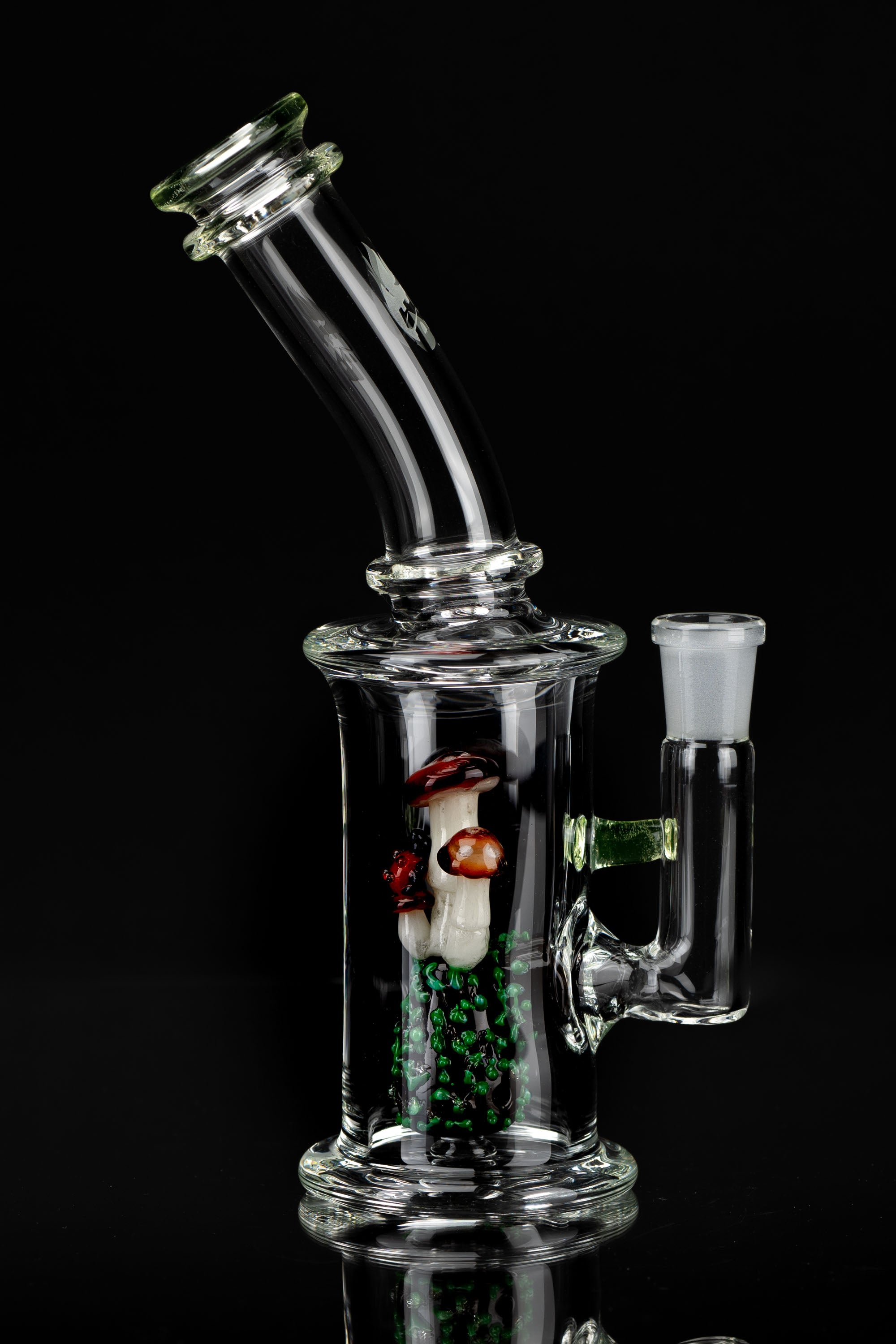 Glass water pipe (bong) with colorful mushroom-themed percolator, studio shot on black.