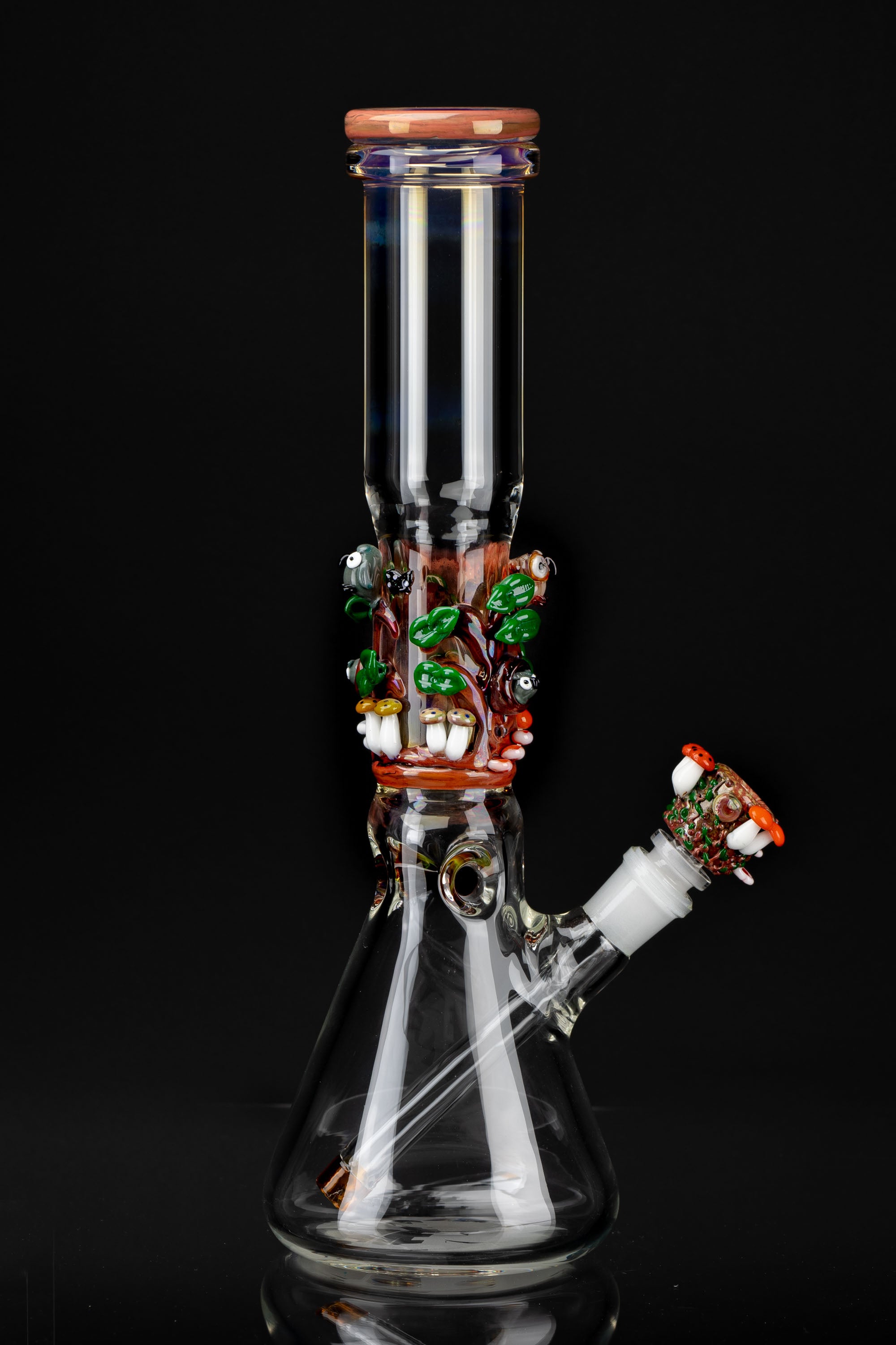 Hand-blown glass water pipe (bong) with colorful sculpted details against a black background.