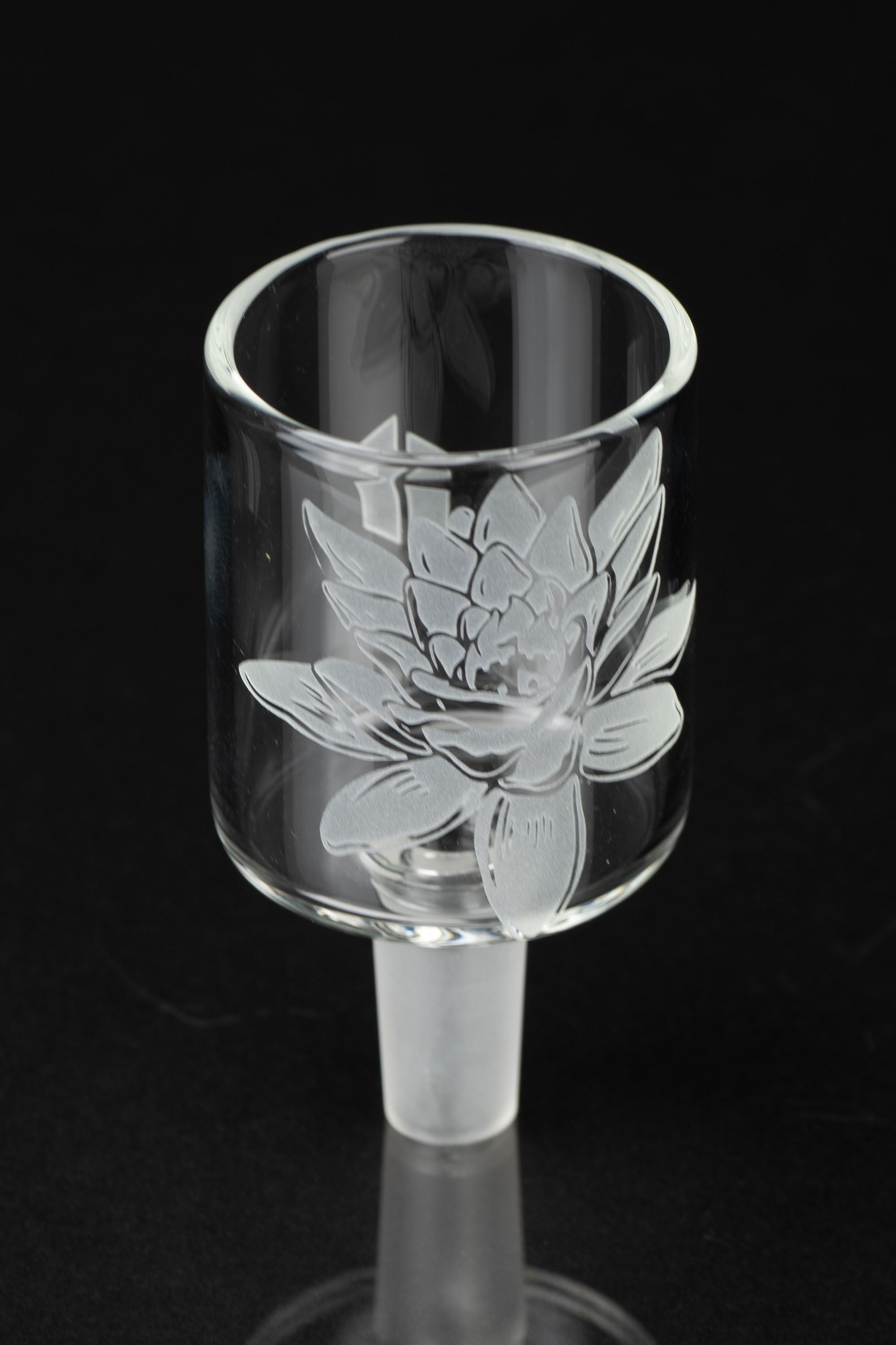 Etched glass cannabis bowl with floral design, studio shot.