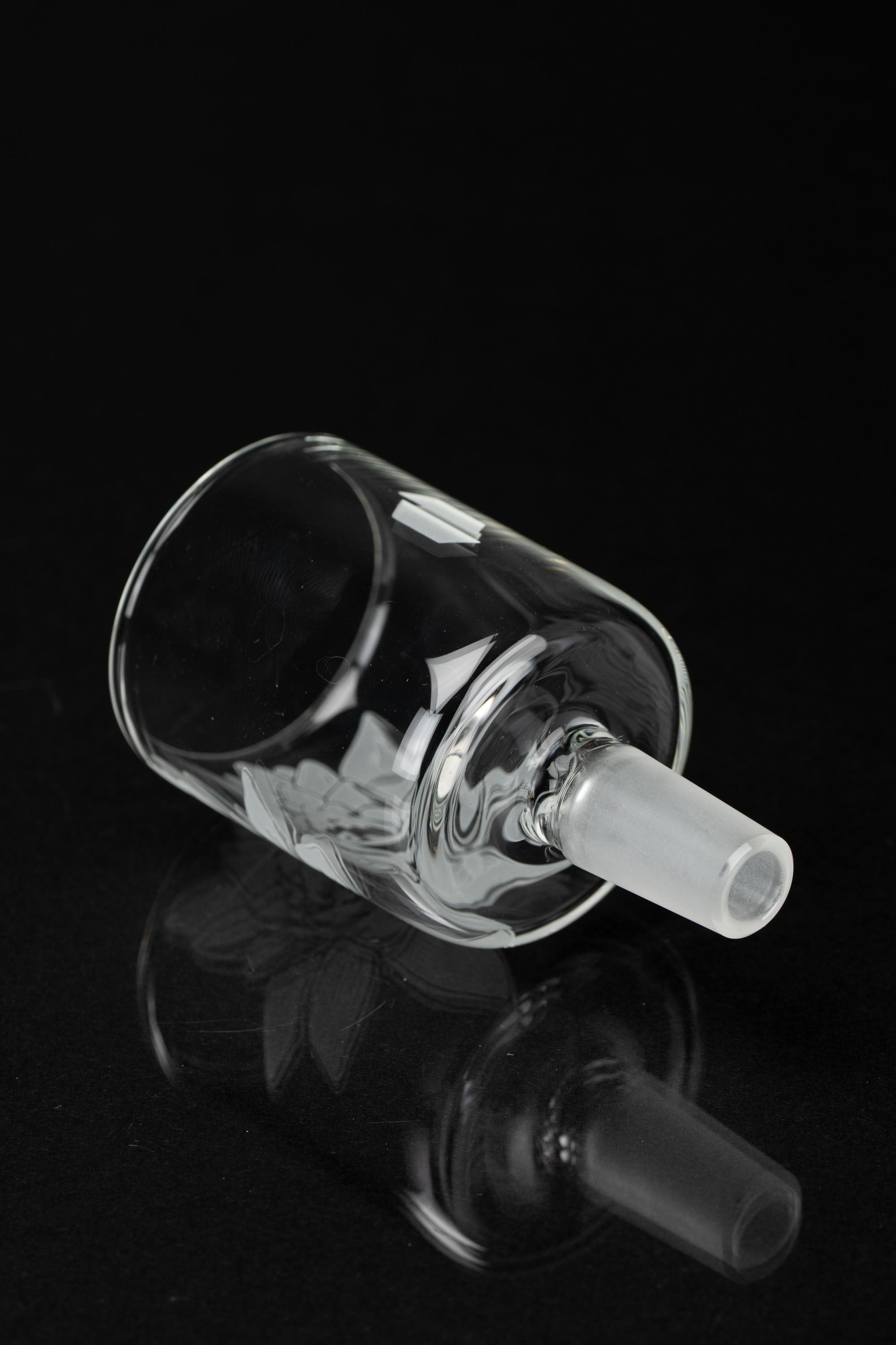 Clear glass bubbler with intricate swirling design, isolated on black.