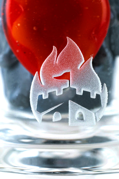 Frosted cannabis leaf design on a glass pipe submerged in water, with a red cap visible above.