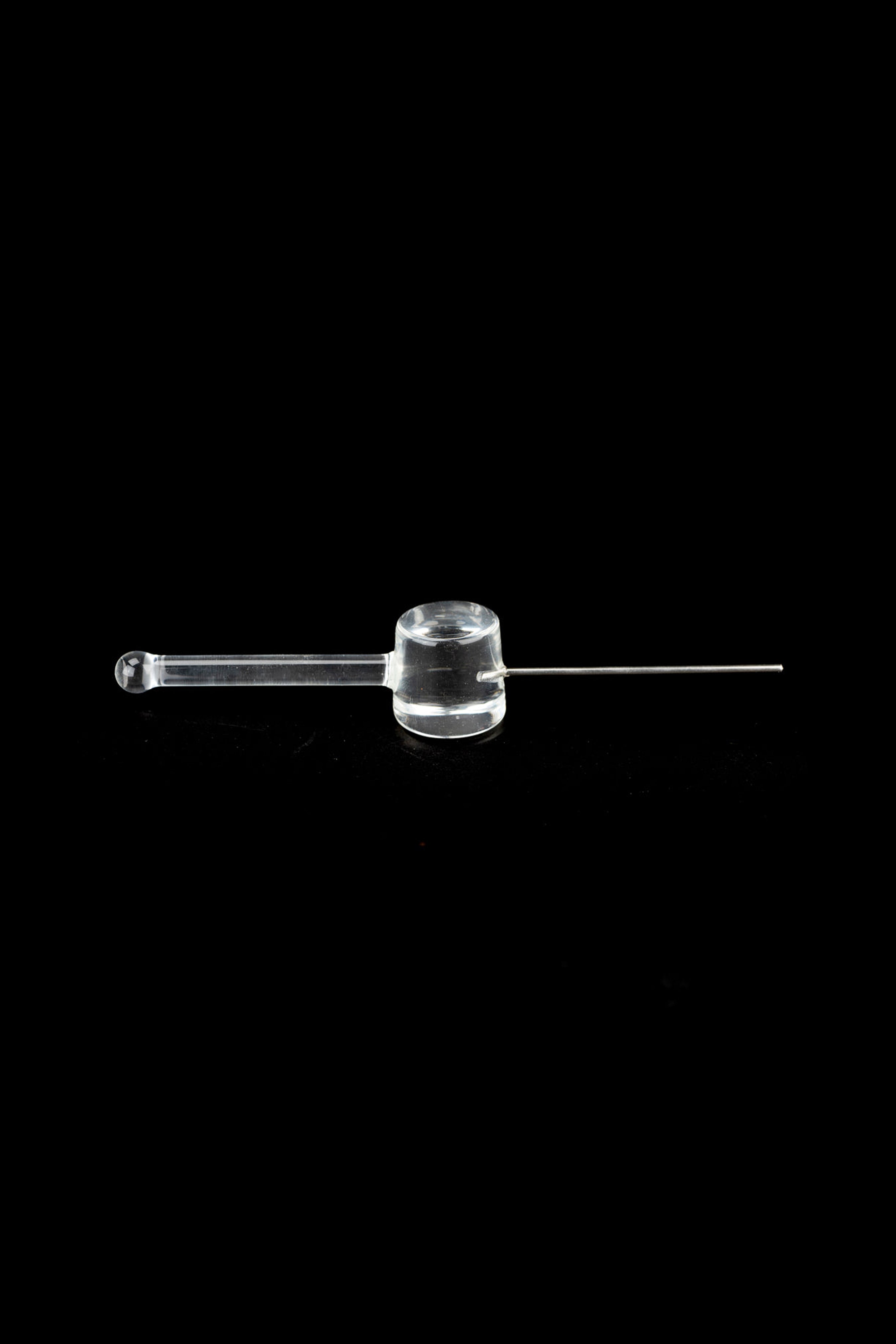 Clear glass oil burner pipe for cannabis concentrates on a black background.