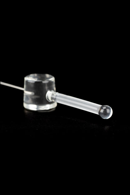 Clear glass oil burner pipe with a spherical tip, isolated on a black background.