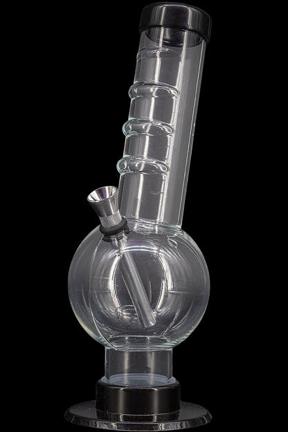 Clear glass water pipe (bong) with a flared base and textured downstem, isolated on a black background.