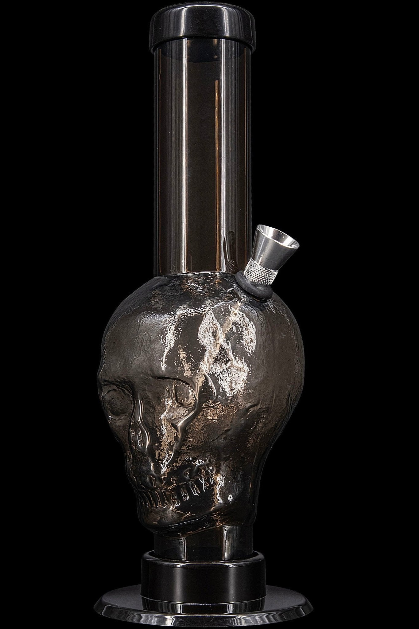 Black glass skull-shaped water pipe (bong) isolated on a black background.