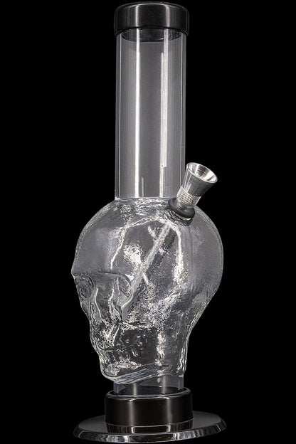 Glass water pipe shaped like a skull, filled with water.