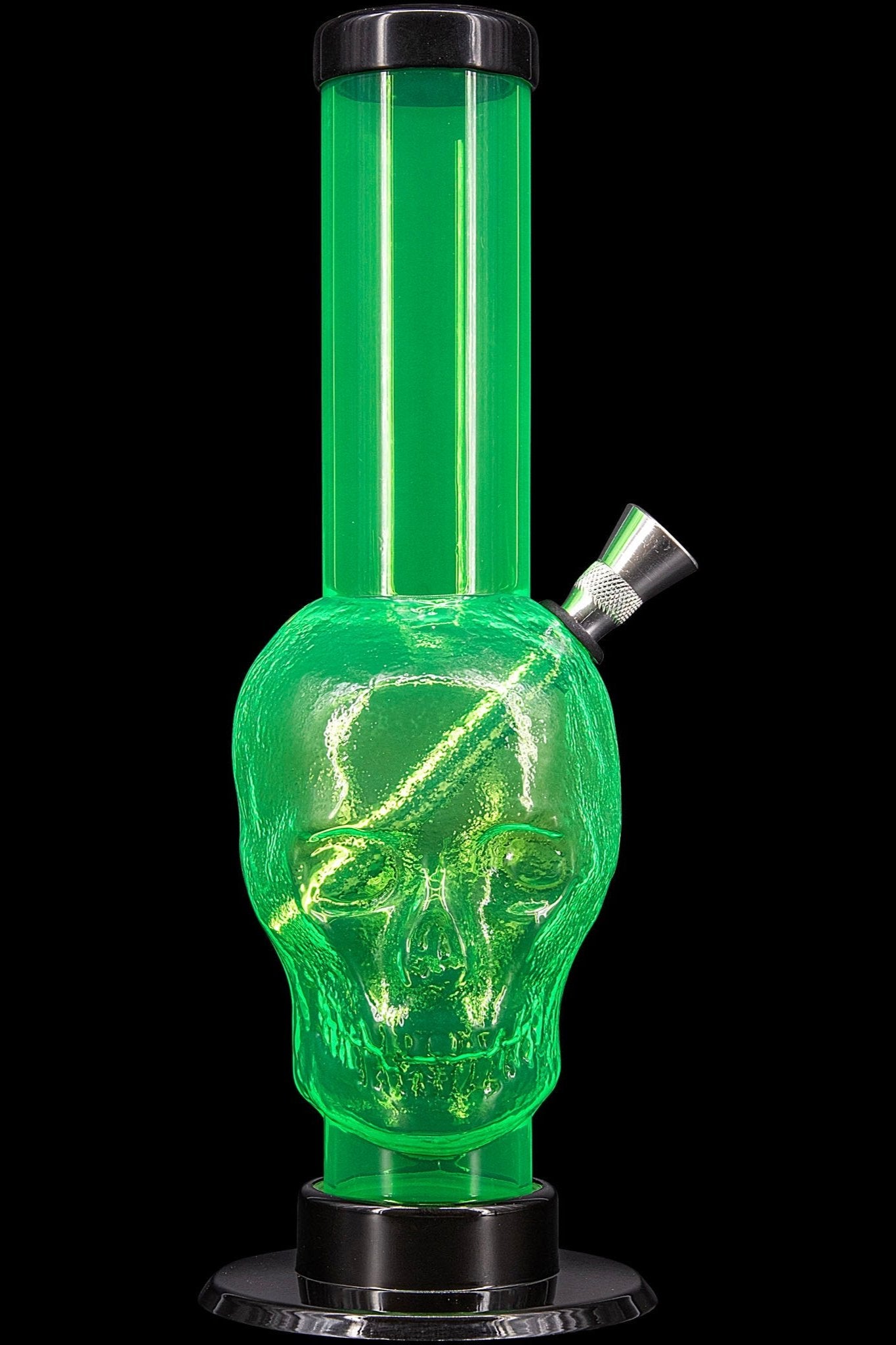Green glass water pipe shaped like a skull, illuminated from within.