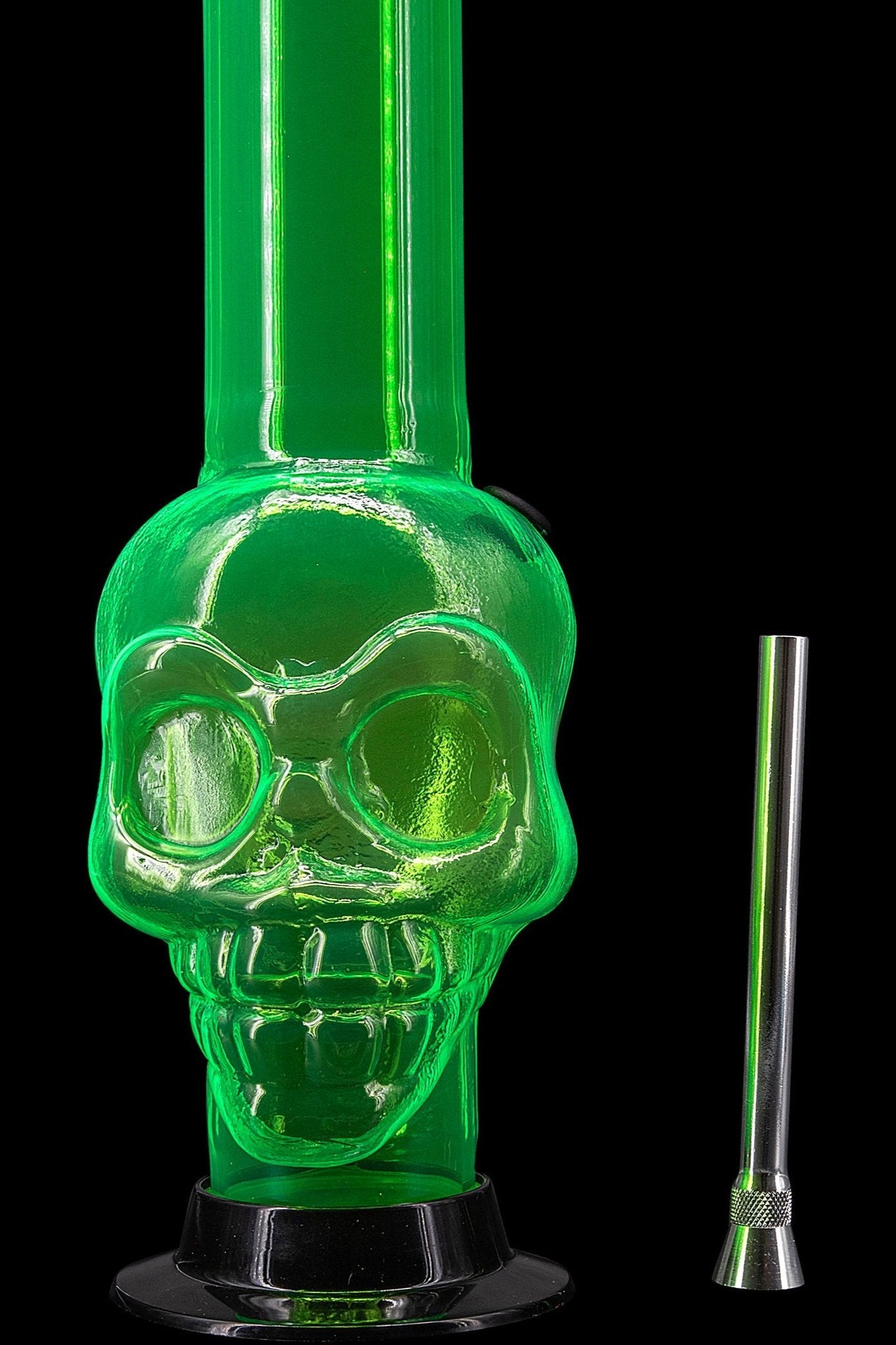 Green glass skull-shaped water pipe with a metal downstem, isolated on a black background.