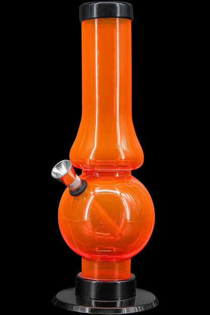 Orange glass water pipe (bong) on a black base.