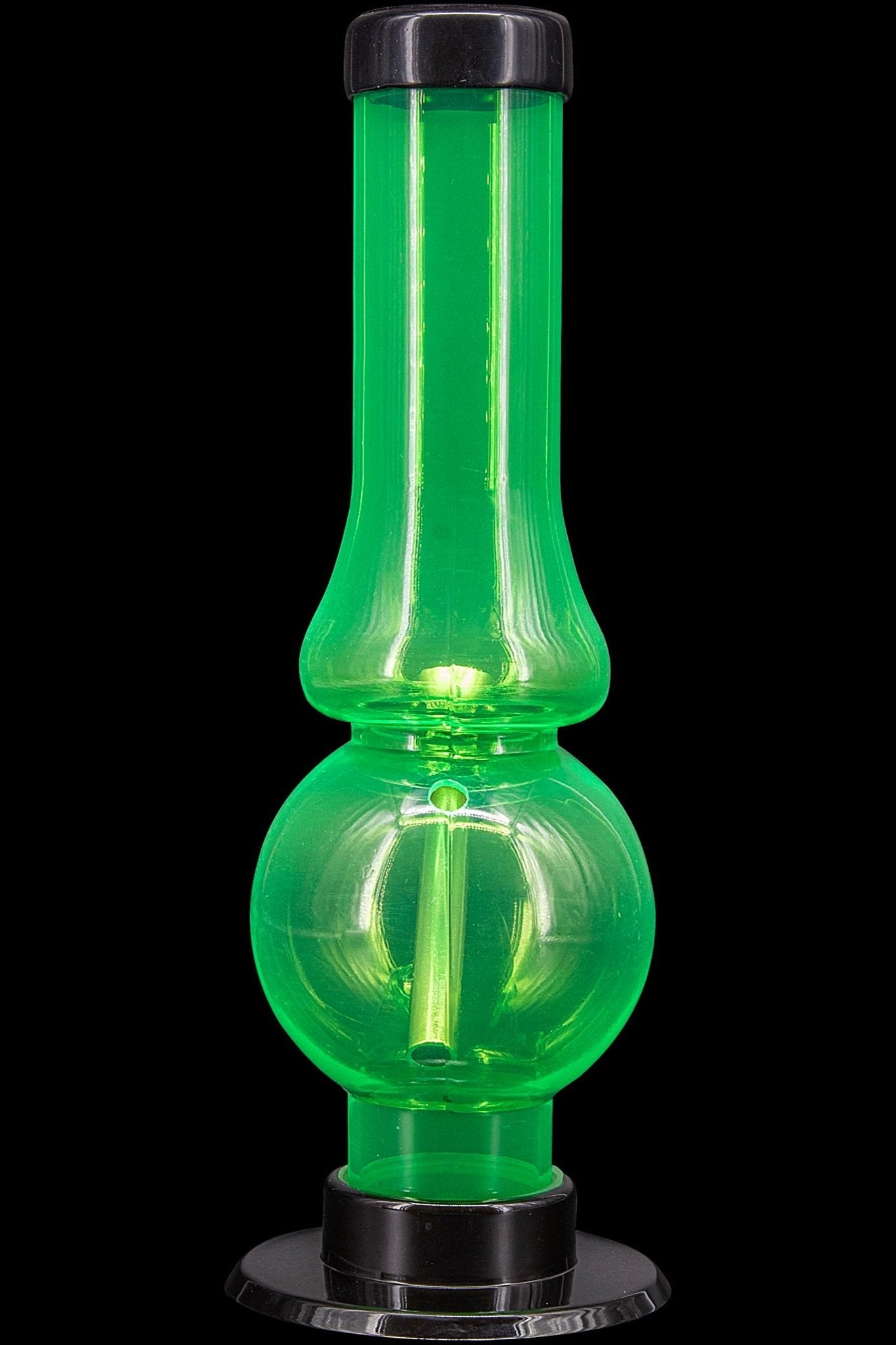 Glowing green glass water pipe, also known as a bubbler, on a black base.
