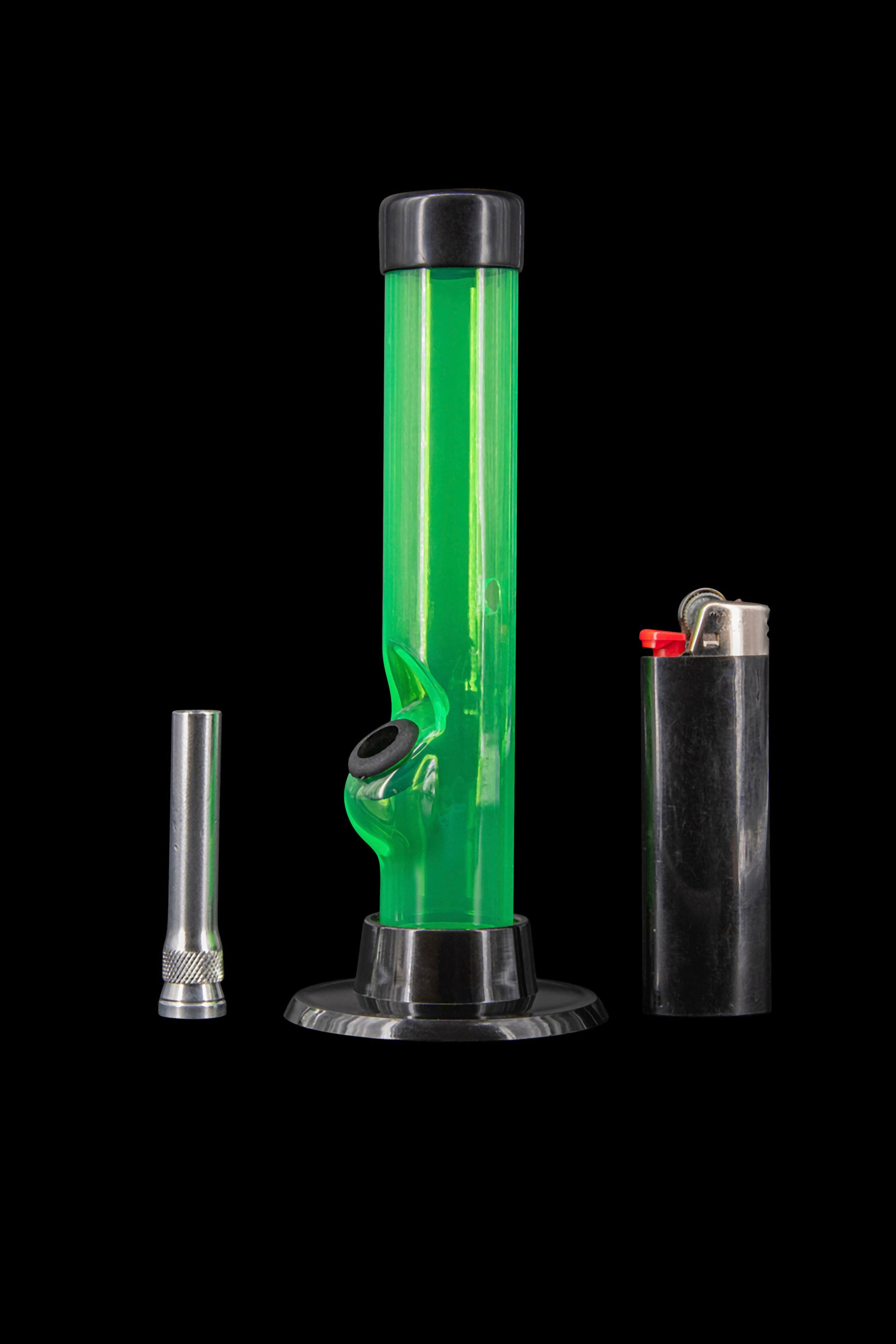 Green glass bong with a metal bowl and lighter on a black background.