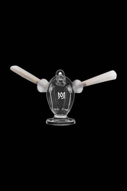 Clear glass dab rig with two carb caps, featuring a branded symbol on the body, isolated on a black background.