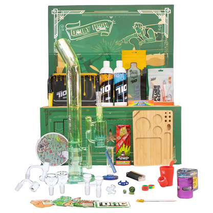 Center-front shot of the green glass rig and accessories arranged in front of the “Epic 420 House Party” Deluxe Box with its illustrated green backdrop.