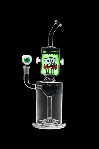 Glass water pipe shaped like Frankenstein's monster with a clear base and green head, isolated on a black background.