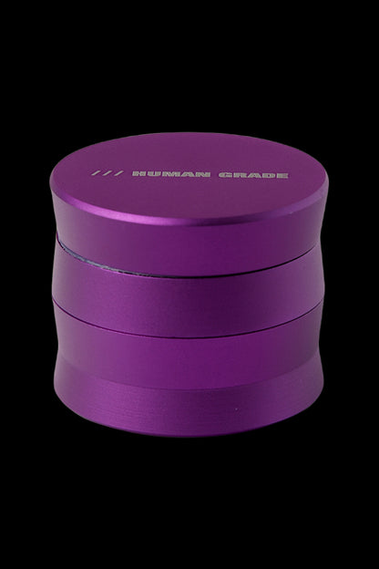 Purple four-piece cannabis grinder with “HUMAN GRADE” etched on top.