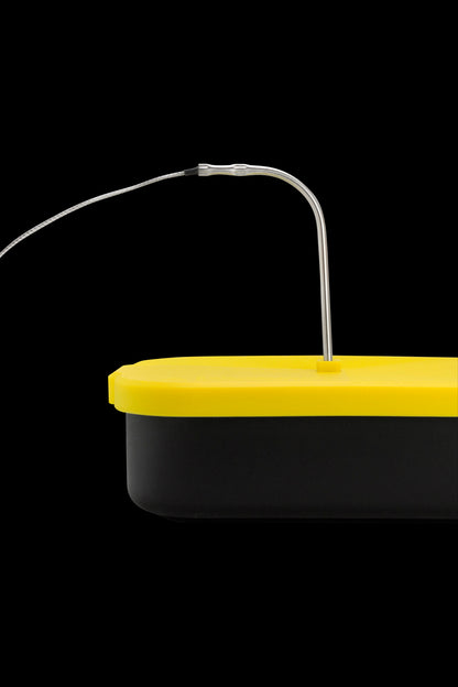 Yellow and black rosin press collection tool with a thin metal probe.